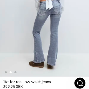 Ljusblå bootcut jeans Gina Tricot - Snygga ljusblå jeans från Gina Tricot med låg midja och bootcut-ben. Jeansen har coola detaljer på bakfickorna med dekorativa sömmar och små nitar. Tillverkade i klassiskt jeansmaterial med lätt tvättad look. Perfekta för dig som gillar retrovibbar. (oanvända)