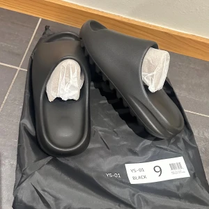 Svarta slides YS-01 strl 9 (Yeezy slides) - Säljer full äkta YS-01 (YEEZY slides) med dustbag. De är helt nya och oanvända. Tveka inte på att höra av sig vid frågor eller fler bilder. ⭐️⭐️⭐️