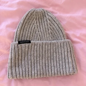Mössa från Peak Performance  - Varm och stor ribbstickad mössa av ullblandning från Peak Performance. Använd fåtal gånger. Nypris 650 kr