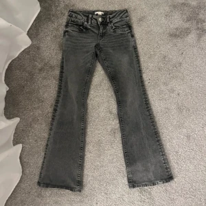 Grå bootcut jeans med låg midja - Snygga grå jeans med bootcut och låg midja. Coola fickor baktill. Använda en gång och är i stl 158 vilket motsvarar XXS/XS