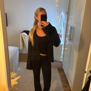 Svart kofta från Nelly med knappar - Säljer en svart kofta från Nelly i storlek S. Koftan har v-ringad hals, långa ärmar och knappar framtill. Den är stickad och har en loose passform som är både chill och snygg. Perfekt att slänga på över ett linne eller t-shirt. Koftan har blivit lite nopprig med utifrån de är den i väldigt bra skick.