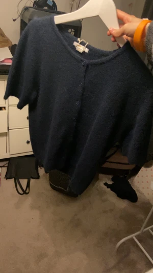 Mörkblå stickad kofta med kort ärm - Säljer denna gulliga mörkblå stickade kortärmade kofta med så skönt tyg från gina tricot i storleken 170 men passar nog allt från xs-m