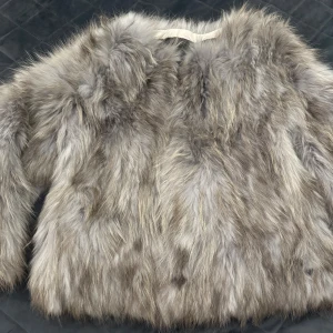 Grå pälsjacka från JinDiaoFur - Säljer en fluffig och lyxig grå pälsjacka från JinDiaoFur. Jackan har långärmad design och är fodrad med svart tyg på insidan. Pälsen har en naturlig grå ton med inslag av ljusare och mörkare nyanser, vilket ger en cool och trendig look. priset kan diskuteras
