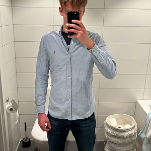Ljusblå skjorta Polo Ralph Lauren M - Snygg ljusblå skjorta från Polo Ralph Lauren i slim fit. Klassisk button-down krage, broderad logga på bröstet och vita knappar. Skjortan är tillverkad i mjuk bomull och har lång ärm. Kostar 1899 kr nypris. Jag på bilden är 187cm lång. Tveka inte på att höra av dig om du har några frågor eller prisförslag!