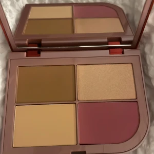 Sminkpalett med bronzer, rouge & highlighter - Snygg sminkpalett från By Beauty Bay med fyra olika nyanser: varm brun bronzer, ljus beige concealer, skimrande champagne highlighter och matt rosa rouge. Kommer i en stilren röd plastförpackning med stor spegel. Perfekt för att skapa en fräsch look.