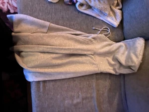 Grå hoodie från Bik Bok med huva - Mysig grå hoodie från Bik Bok i storlek S. Klassisk modell med stor känguruficka framtill, dragsko i huvan och ribbade muddar. Perfekt för chill dagar eller när du vill ha något bekvämt och stilrent. Materialet är mjukt och skönt mot huden.