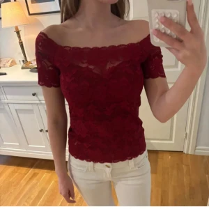 Vinröd blus - Säljer denna fina vinröda blus med mönster och offsoulder. Perfekt nu till jul eller andra tillställningar.