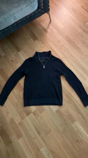 Mörkblå stickad half zip från Jack & Jones - Den är i hövligt bra skick,snygg mörkblå stickad tröja från Jack & Jones Premium med ribbad struktur och half zip-dragkedja i halsen. Tröjan har långärmad passform och är perfekt för dig som gillar stilrena och bekväma plagg. Passar dig som vill ha en klassisk look med modern touch.