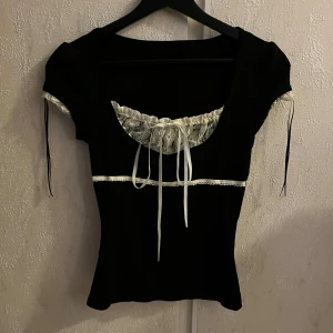 Svart topp med rosetter och spetsdetaljer - Svart topp i storlek S från yesstyle. Inte min stil längre.