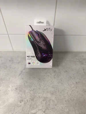  Gaming Mouse - Xtrfy MZ1 RGB är en ultralätt gamingmus med RGB-belysning, ergonomisk design och perforerat skal för minskad vikt. Komplett med originalkartong och tillbehör, i nyskick utan synligt slitage. Perfekt för snabba och precisa rörelser vid gaming. Aldrig använd bara vid test aldrig spelat med den. Pris kan diskuteras vid snabb affär 💨  