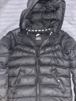Svart pufferjacka från Nike - Svart pufferjacka från Nike med huva och dragkedja framtill. Jackan är i barnstorlek M, 137-147 cm. Skicket är mycket bra och jag svarar gärna på era frågor 😀 