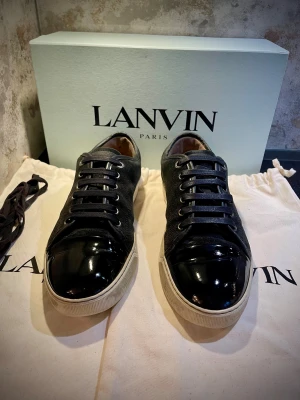 Lanvin Patent Cap toe sneakers - Säljer nu dessa riktigt snygga Lanvins i storlek UK 8 vilket motsvarar 42-43 ungefär 🙌 Mockan är i nästintill perfekt skick, sulan är vit och fin. Alla sömmar är intakt osv! Cap toen har inga repor alls! Enda defekten är en liten defekt på sulan i form av lite heeldrag på höger sko, vilket man ej lägger märke till vid första anblick eller känner av när man har på sig skorna🤩.  Perfekt till vinter❄️TILLBEHÖR:SKOLÅDA, 2ST DUSTBAGS, EXTRA SKOSNÖREN 😊 Skriv vid funderingar📲 kom gärna med prisförslag🙏