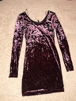 Lila sammetklänning från H&M, stl 34(xxs/xs) - Superfin lila i sammet från H&M. Klänningen har lång ärm, rundad urringning. Perfekt för dig som vill sticka ut med en glansig och mjuk look.