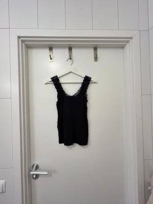 Svart linne med spetsdetaljer från Vero Moda - Svart linne med spetsdetaljer från Vero Moda i storlek Small. Använd 1 gång, mycket bra skicka🫶🏼