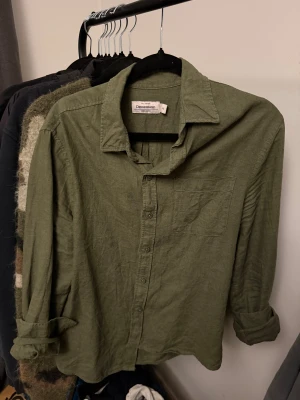 Grön linneskjorta från Dressmann XS - Snygg grön skjorta från Dressmann i linnemix, perfekt för dig som gillar en chill och stilren look. Skjortan har klassisk krage, knappstängning framtill och en bröstficka. Långärmad modell med uppvikta ärmar för extra avslappnad vibe.