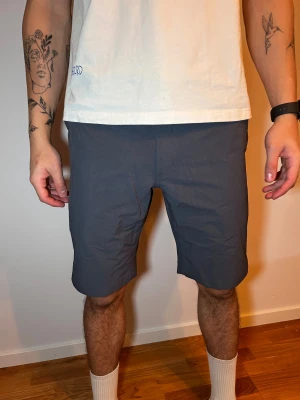Mörkgrå midwaist shorts Haglöfs - Snygga mörkgrå shorts från haglöfs med midwaist passform och raka ben. De har praktiska sidofickor och är tillverkade i ett lätt och bekvämt syntetmaterial som passar perfekt för varma dagar. Enkel design utan mönster eller extra detaljer, vilket gör dem riktigt clean.