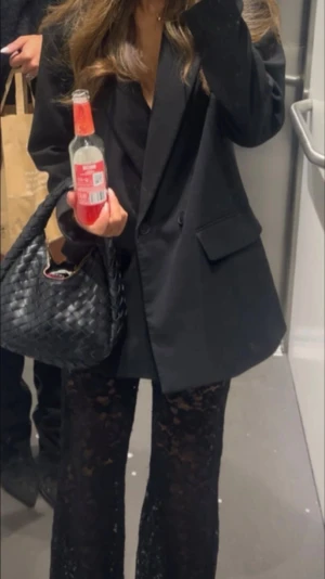 Svarta spetsbyxor - Säljer ett par svarta byxor i transparent spets med blommigt mönster. Byxorna har en wide fit och rak siluett som ger en snygg och trendig look. Perfekta att styla med en oversized kavaj för en cool outfit. Materialet är mjukt och följsamt.