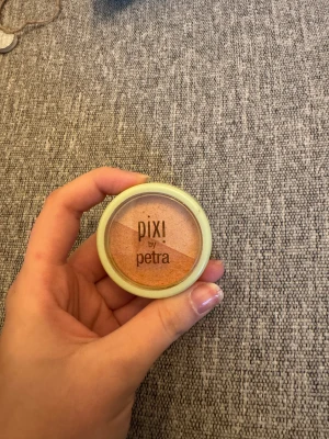 Pixi Beauty Blush Duo Peach Honey - Säljer en Pixi Beauty Blush Duo i färgen Peach Honey. Den har två nyanser: en persikotonad och en ljusare champagnefärgad, perfekt för att ge kinderna glow. Kommer i en rund mintgrön dosa med transparent lock. Innehåller 4,5g puderformula.