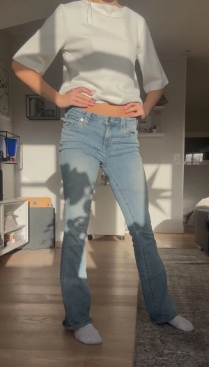 Ljusblå bootcut jeans från True Religion - Snygga ljusblå jeans från True Religion. Dem är mid waist men går utmärkt bra att sy ner. Använt max 2 gånger där av säljes. De är uppsydda till nån som är 174cm men går att länga. Storlek är w27