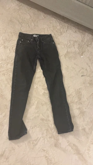 Svarta straight  jeans från lager 157 - Jeans med låg midja och rak passform. Fickor fram och baktill. Knappgylf samt hällor för bälte. Jeansen är en fullängdsmodell gjord i en denim i 100% bomull utan stretch 