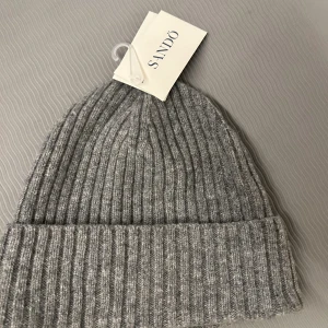 Mössa från Sand - Säljer denna snygga gråa mösan från Sand som är helt ny! Jag säljer den eftersom den inte riktigt passade mig. Bara att höra av sig vid funderingar!