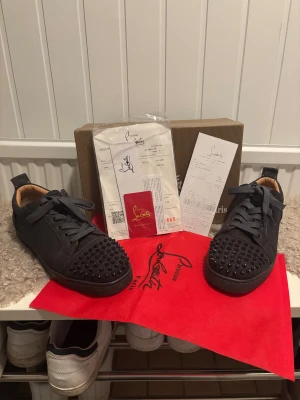 Christian Louboutin svarta sneakers med nitar - Säljer ett par väldigt fina Christian Louboutin skor. Skorna kommer med tillbehör som syns på bilden. Nypris ca6800kr. Priset kan diskuteras.                                       Har du fler frågor så tveka inte på att höra av dig🙃