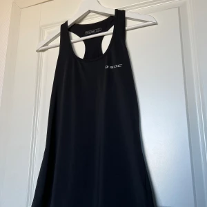 Svart SOC träningslinne - Bekvämt svart SOC träningslinne. Lös passform med skönt och svalt material. Nätöppning i ryggen för mer luftflöde. Storlek 36, normal i storleken.