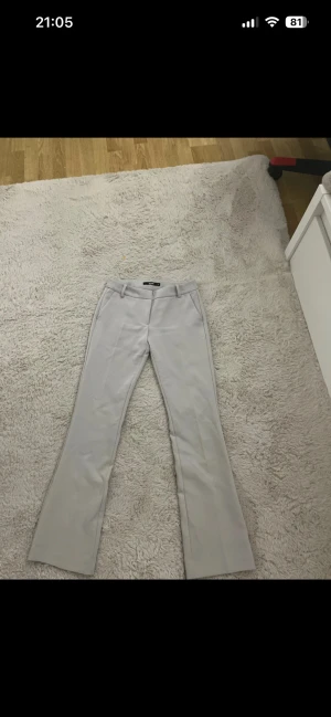 Beige bootcut kostymbyxor Bik Bok - Snygga beige kostymbyxor från Bik Bok i storlek 34. Har använt byxorna en gång så nästan helt oanvända.