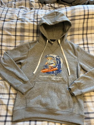Grå hoodie Polo Bear från Ralph Lauren - Säljer en riktigt fet Hoddie Polo Bear från Ralph Lauren. Nästan alldrig använd finns inget märka på användning. Storlek M. Skirv vid fler bilder eller frågor. Perfekt som julklapp eller bara unna sig själv🌟💥Klicka på bilden när den sitter på mig så ser ni bättre💪🏻