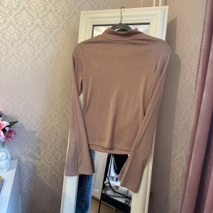 Ribbad polotopp - Toppen har lång ärm, smal passform och en mjuk, stretchig känsla. 