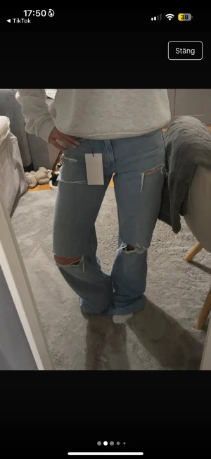 Blå ripped wide jeans från Zara - Bilderna är från min vinted så ni behöver ej fråga om egna bilder❤️Säljer ett par ljusblå jeans från Zara i storlek 34 med breda ben och snygga slitningar på både fram- och baksida. Modellen är high waist och har klassisk femficksdesign. Perfekt för dig som gillar en avslappnad och trendig look.
