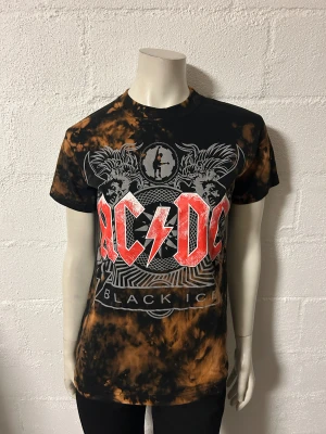 AC/DC Black Ice t-shirt med batikmönster xs - T-shirt med ACDC. Storlek XS. Fina meleringar på. Endast provad.