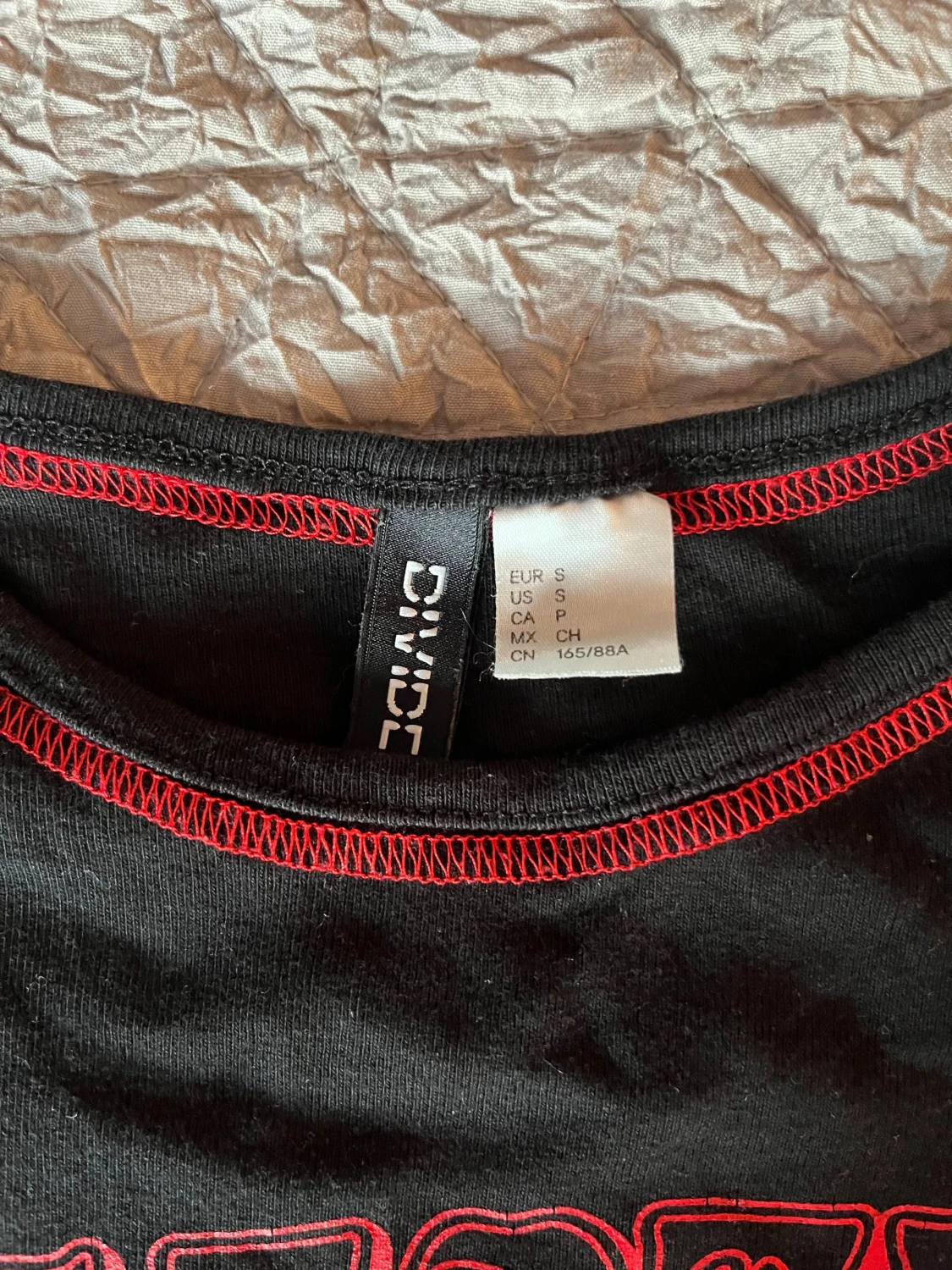 Svart croppad topp med röd print från DIVIDED - 2