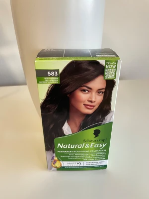 Schwarzkopf Natural & Easy 583 Frostig Mörkbrun - Permanent hårfärg från Schwarzkopf i nyansen 583 Frostig Mörkbrun. Färgen ger ett naturligt och glansigt resultat med 100% grå täckning. Innehåller medelhavsolivolja och fransk lavendelvatten för extra vård. Förpackningen är grön och svart med tydliga instruktioner.