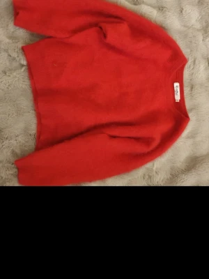 Röd stickad tröja från Rizomic - Mysig röd stickad tröja från Rizomic i storlek XXS. Tröjan har rund halsringning och långa ärmar. Perfekt för kyliga dagar och enkel att matcha med jeans eller kjol.