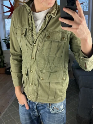 Fieldjacket olivgrön  - Trendig och väldigt snygg, bra skick. Mått: A:44 B:43 C:54 D:64 (cm) skriv vid fundering 😇✌️
