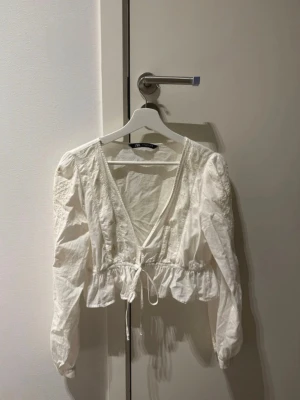Vit broderad blus  - Säljer denna fina broderade blus från Zara då den inte kommer till användning! Fin urringning med volanger! Storlek M men passar även S. Använd 1 gång så är som ny, den är lite skrynklig bara men när man stryker den blir de bättre!!