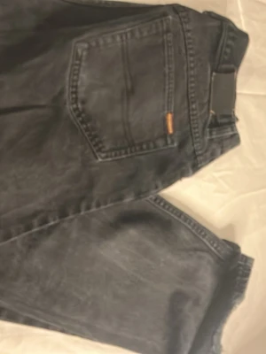 Svarta Petroff jeans straight fit - Säljer ett par svarta jeans från Petroff med klassisk femficksdesign och raka ben. Jeansen har metallknappar och detaljer i kopparfärg samt Petroff-logga på linningen. Materialet är 100% bomull och de har en tidlös, enkel look.