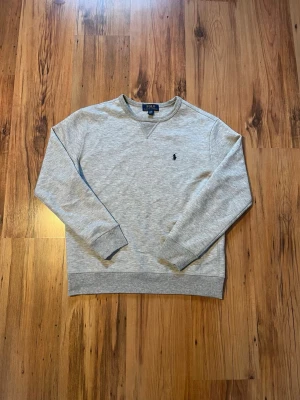 Grå sweatshirt från Polo Ralph Lauren S/170 - Äkta grå Ralph lauren tjock tröja 🐎Tröjan mäter 60 cm i längd, 47 cm i bredd, 54 cm i ärmlängd. Den är i jättefint skick och har inga skador eller defekter. 