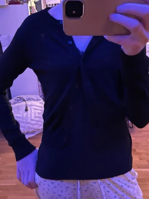 Svart kofta med knappar - svart kofta med knappar framtill, lång i ärmarna men kort modell framtill. sitter lagom tajt men stretchigt tyg.