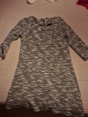 Gråmelerad klänning från Isolde M - Säljer en gråmelerad kortklänning från Isolde i storlek M. Klänningen har trekvartsärm, rund halsringning och dragkedja i ryggen. Materialet är tjockt och mjukt, perfekt för kyligare dagar. Mönstret är diskret rutig och färgen går i grått och vitt. Skulle passa helt otroligt med tights och boots på en kylig dag så man kan se stilig ut men även hålls sig varm! Priset kan diskuteras🫶