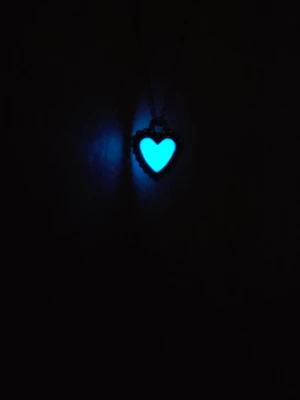 Handgjort hänge med turkost sken | 45 cm - Säljer ett vackert halsband som jag har skapat själv. Hänget har en ljus, diskret ton i dagsljus men får ett magiskt turkost sken i mörkret efter att det laddats upp i ljus. Ett personligt smycke som är fint både på fram- och baksidan. ​Jag använder endast material av hög kvalitet som är hållbara och helt fria från farliga kemikalier. Kedjan är i rostfritt stål.  ​Kedja: 45 cm. ​Hänge: 1,5 cm. ​Material: Rostfritt stål och högkvalitativt glow-material. ​Färg: Vit/ljusgrön i ljus, turkos I mörker