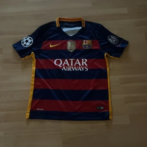 FC Barcelona Neymar Jr 11 Nike tröja S - Säljer en officiell FC Barcelona matchtröja från Nike med Neymar Jr och nummer 11 på ryggen. Tröjan är randig i mörkblått och rött med gula detaljer, tillverkad i Dri-FIT material. Champions League-märke på ärmen och Qatar Airways-tryck på bröstet.