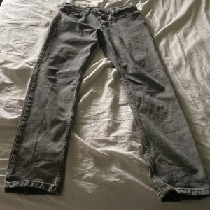 Grå Levi's 511 jeans, W29 L32 - Säljer ett par grå Levi's 511 jeans med klassisk femficksdesign och raka ben. Jeansen har en snygg, mörkgrå tvätt och är tillverkade i bomullsdenim. Passformen är slim och modellen är midwaist. Perfekta för dig som gillar en stilren och tidlös look.