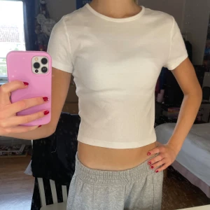 Vit croppad ribbad topp🤍 - Säljer en vit croppad topp från H&M på Divided i ribbad bomull. Modellen har rund hals, korta ärmar och sitter tight mot kroppen. Perfekt basic att styla med jeans eller kjol. Enkel och fräsch design som funkar till allt😍