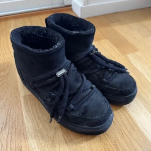 Inuikii - Säljer ett par svarta vinterskor från Inuikii med mjuk päls på insidan och mocka på utsidan. Skorna har grova snören och en platt sula, perfekta för kalla vinterdagar. Snygg och chunky look som passar till streetwear. Detta är utan att dem är rengjorda och är nästan i nytt skick.
