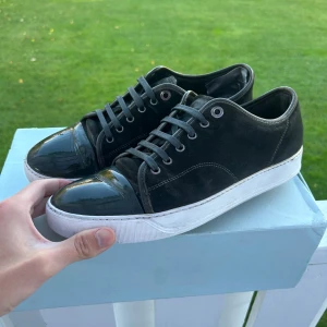 Lanvin - Säljer ett par svarta lanvin med en hint grön, ganska bra skick ända är hälen och lite creases där framme och lite sliten sula (se bild) uk 9 så 43 men passar 44 också, pris går att diskutera vid snabb affär, box medföljer inte, sulkräm har använts.