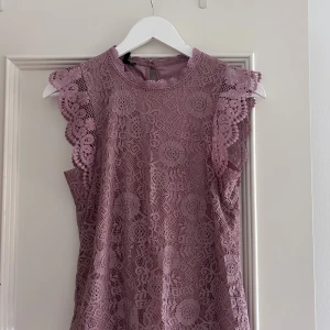 Ljuslila spets blus med volang - Säljer denna jättefina blus från pieces!! Skriv för fler bilder. Säljer denna då den knappt kommer till användning. Pris går att diskutera vid snabb affär💗