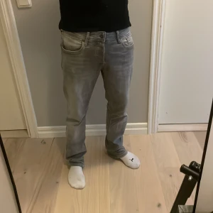Grå jeans från Jack & Jones - Säljer ett par grå jeans från Jack & Jones i modellen regular fit/clark. Jeansen har en klassisk design, raka ben och normal passform. Materialet är väldigt mjukt och skönt och färgen är snyggt tvättad grå. Perfekta för en laidback och grisch outfit.