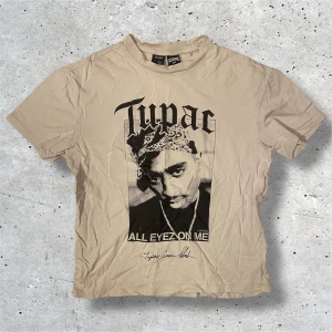 Tupac T-Shirt - Säljer denna t-shirten från Bershka med tryck av Tupac. Tröjan kommer i storlek XS men är lite oversized och passar därav S också, den har inga defekter (den är skrynklig för att jag inte har strykt den). Hör av er vid frågor, pris kan diskuteras!